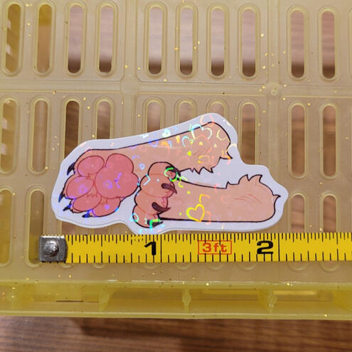 A photo of a holographic dog paws sticker.